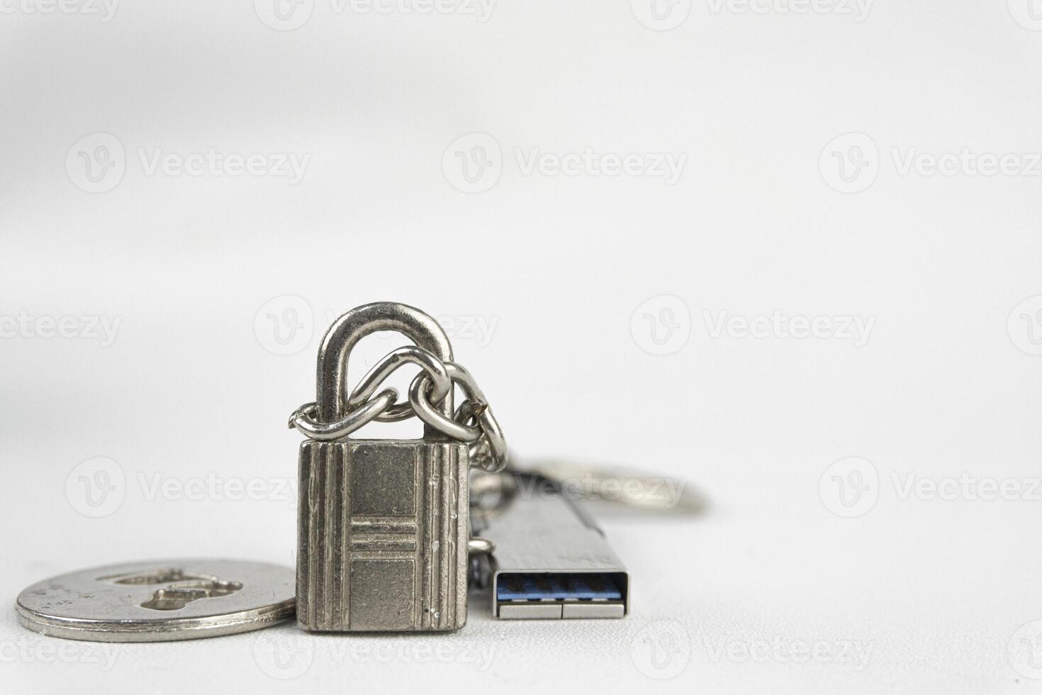 A padlock, coin, and USB flash drive lie on a white surface, symbolizing data security and storage. photo