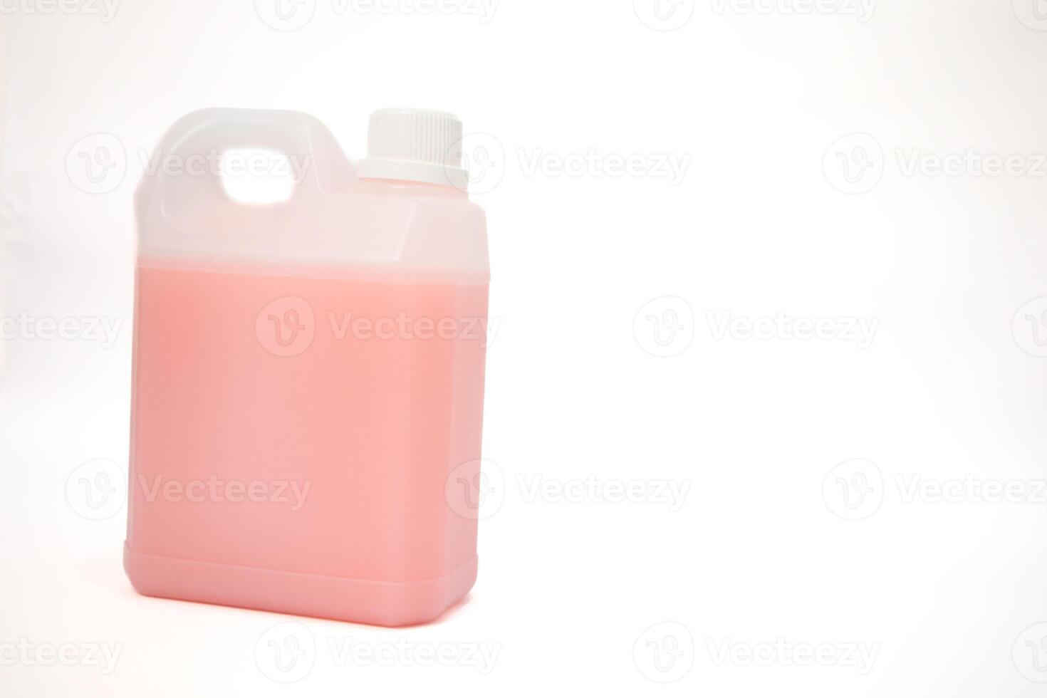 A plastic gallon container filled with pink liquid sits on a white background ready for use photo