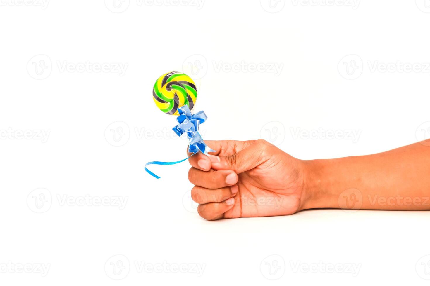 A hand holding a brightly colored lollipop against a stark white background, showcasing the sweetness and joy of a sugary treat photo
