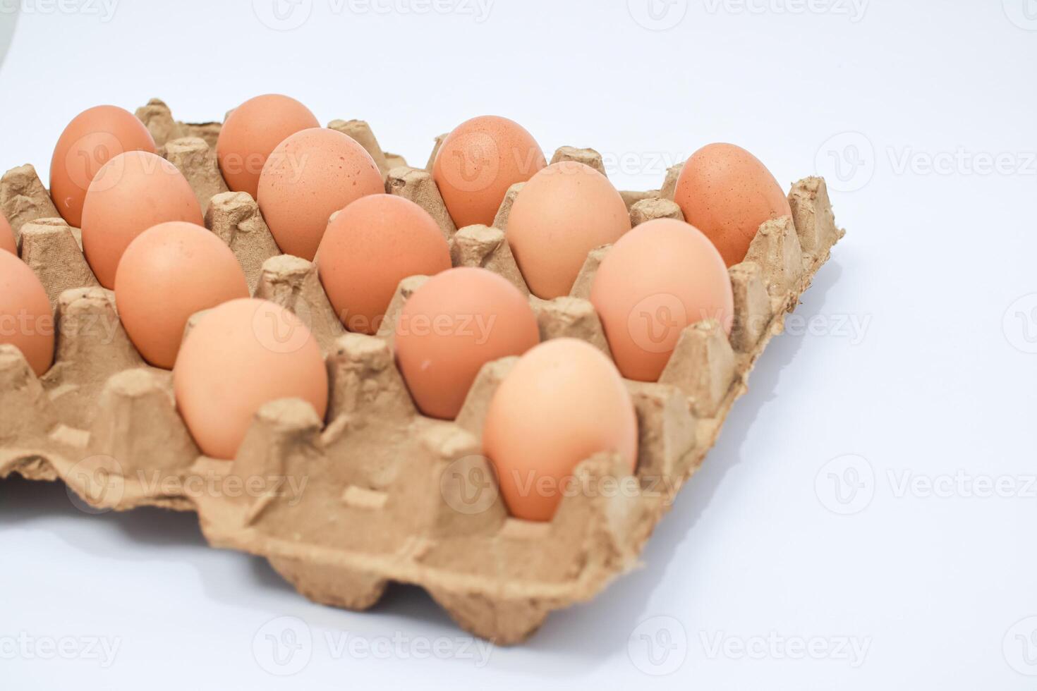 Light Brown Eggs In Egg Carton On White Background photo