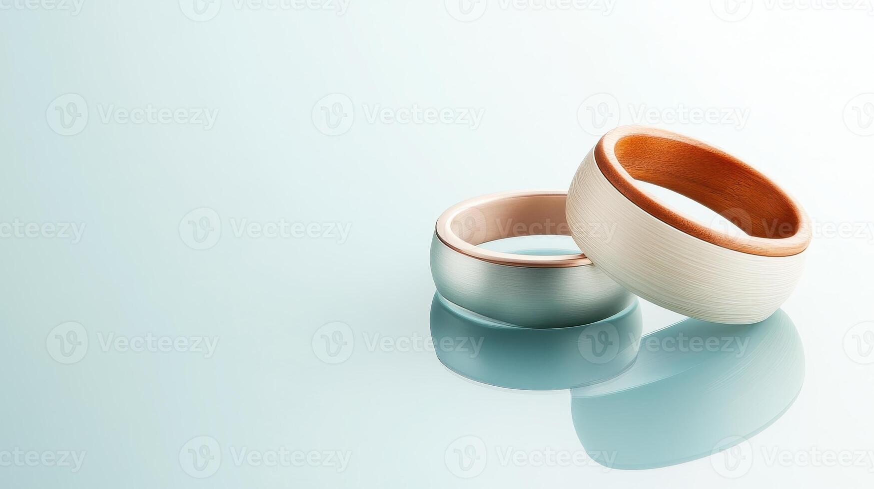 Modern rings displaying futuristic fashion elements sit on reflective surface against bright backdrop. Clean concept. photo