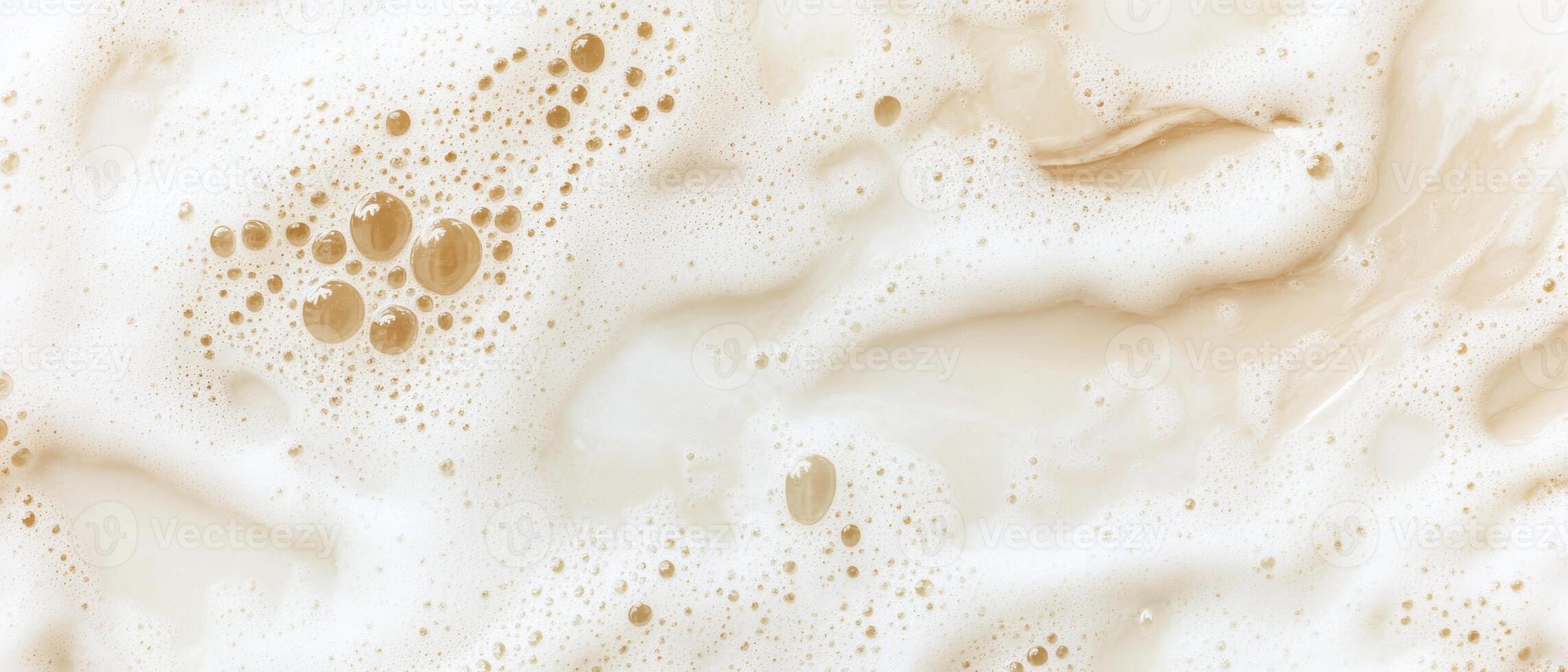 Tan liquid surface with many bubbles and foam swirling around, creating abstract patterns and textures, filling the frame with soft neutral tones. photo