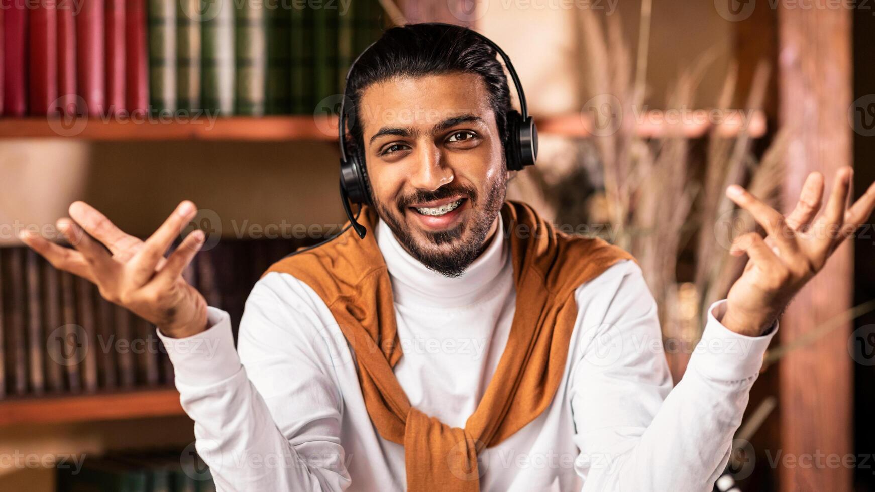 Smiling Arab Teacher Guy Talking To Camera Teaching Online Wearing Headphones Having Distance Class Sitting At Home. Remote Education, Distant Teaching And Learning Concept photo