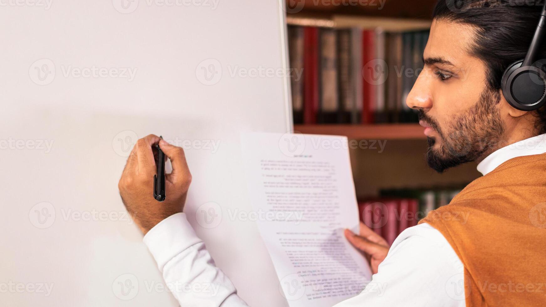 Arab Teacher Man Teaching English Language Writing Grammar Rules On Blackboard Having Online Class Lecture Standing Indoors. Tutoring, Distance E-Teaching And E-Learning Concept photo