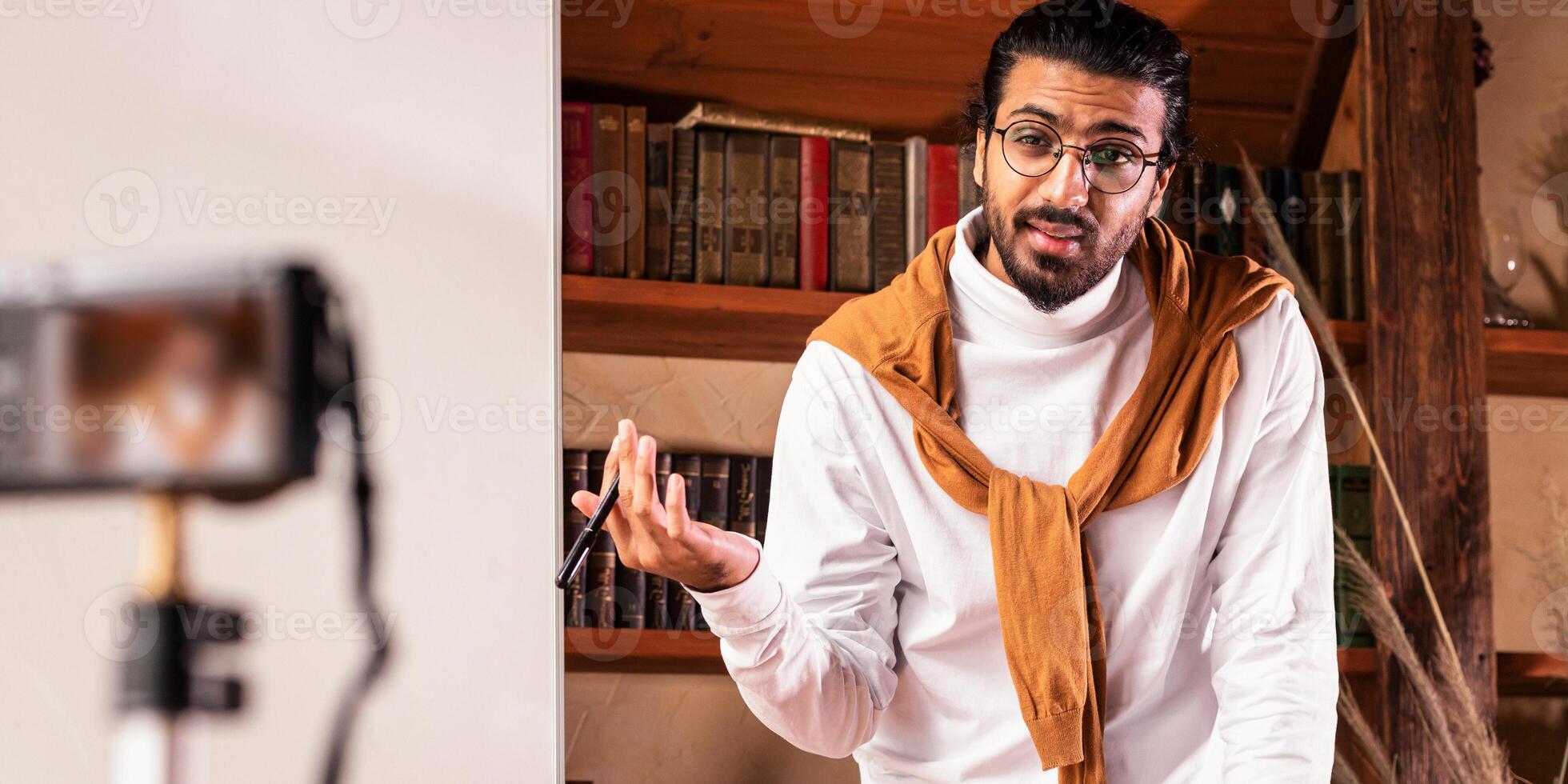 Arab Teacher Man Making Lecture For Educational Webinar Teaching English Online Standing Near Blackboard And Talking To Camera Indoors. Modern Remote Education, E-Teaching And E-Learning photo