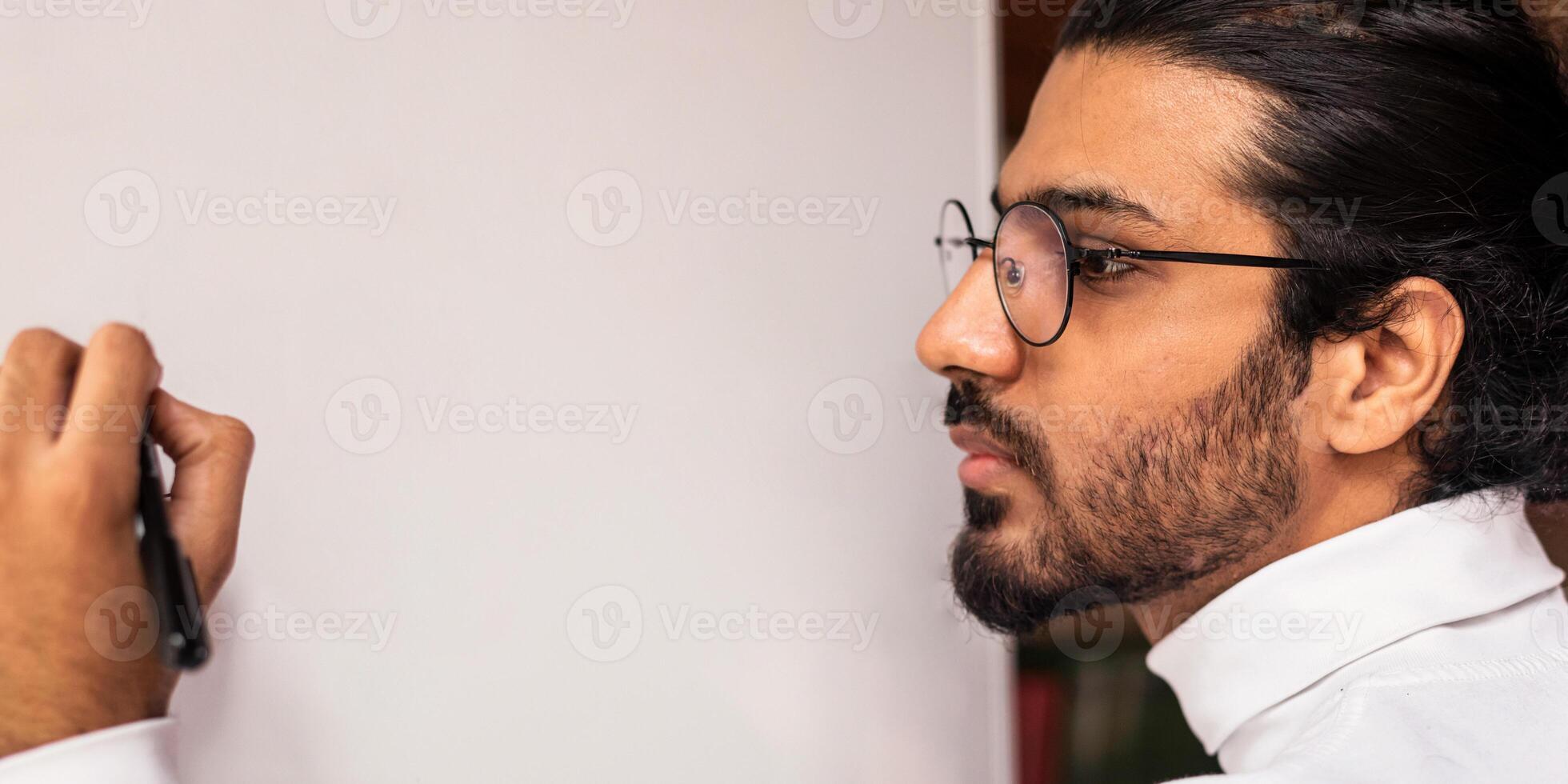 English Lesson. Young Indian Teacher Writing English Language Grammar Rules On Blackboard Teaching During Class Indoors. Education And Knowledge Concept. Selective Focus photo