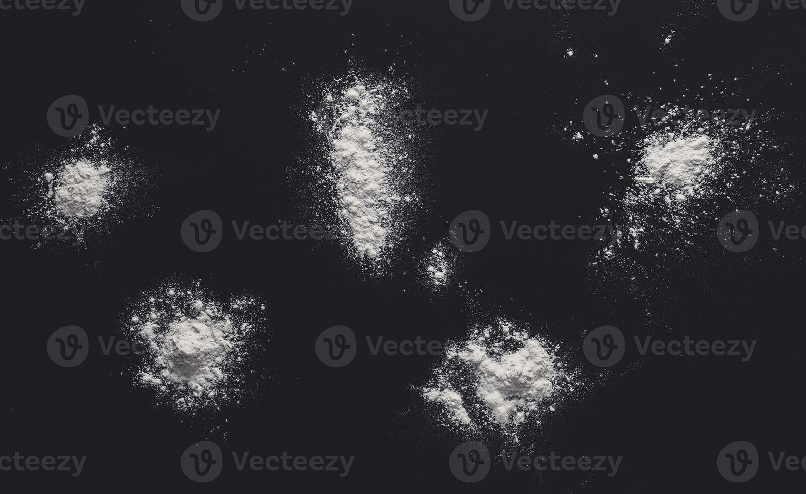 White flour splash spot on black background. Top view on blackboard. Baking concept, cooking dough or pastry. photo