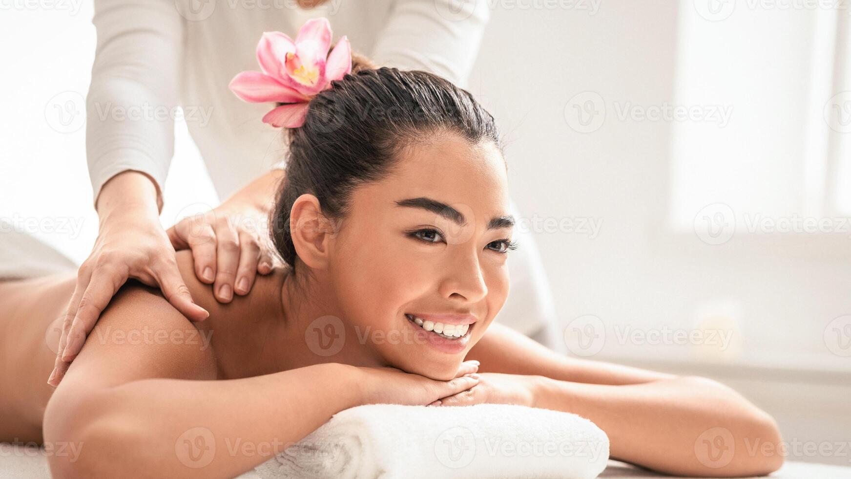 Relaxing Massage. Young asian woman getting classical body treatment at spa salon, lying on comfortable table with towel under head, beautiful korean lady pampering herself with beauty procedure. photo