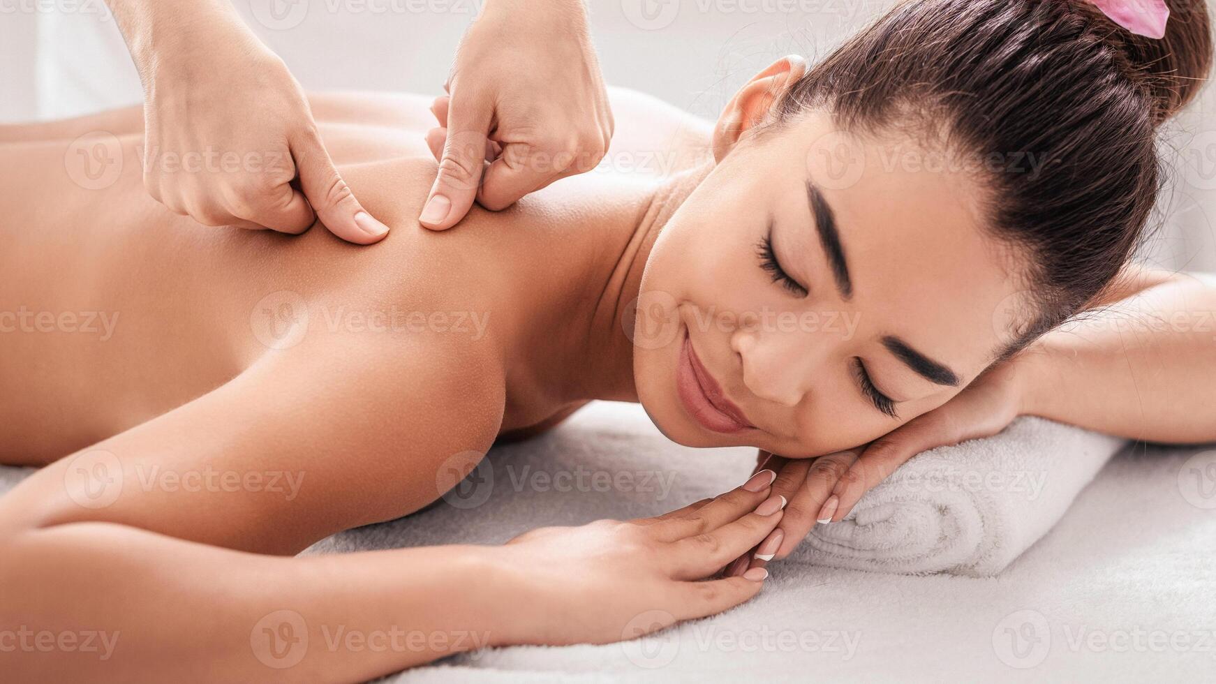 Relaxing Massage. Professional Body Therapist Massaging Back Of Relaxed Asian Woman In Spa Salon, Beautiful Young Korean Female Enjoying Wellness Treatment And Beauty Procedures, Closeup photo