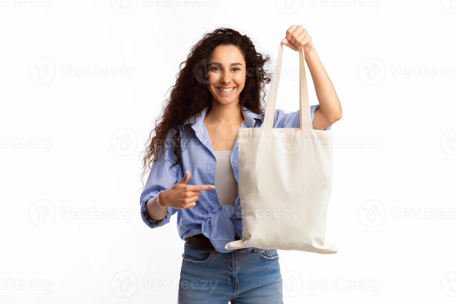 Use Eco Bag. Smiling Woman Pointing Finger At White Textile Shopper Handbag Standing Over White Studio Background. Eco-Friendly Lifestyle, Fashion And Ecology, Stop Using Plastic Concept photo