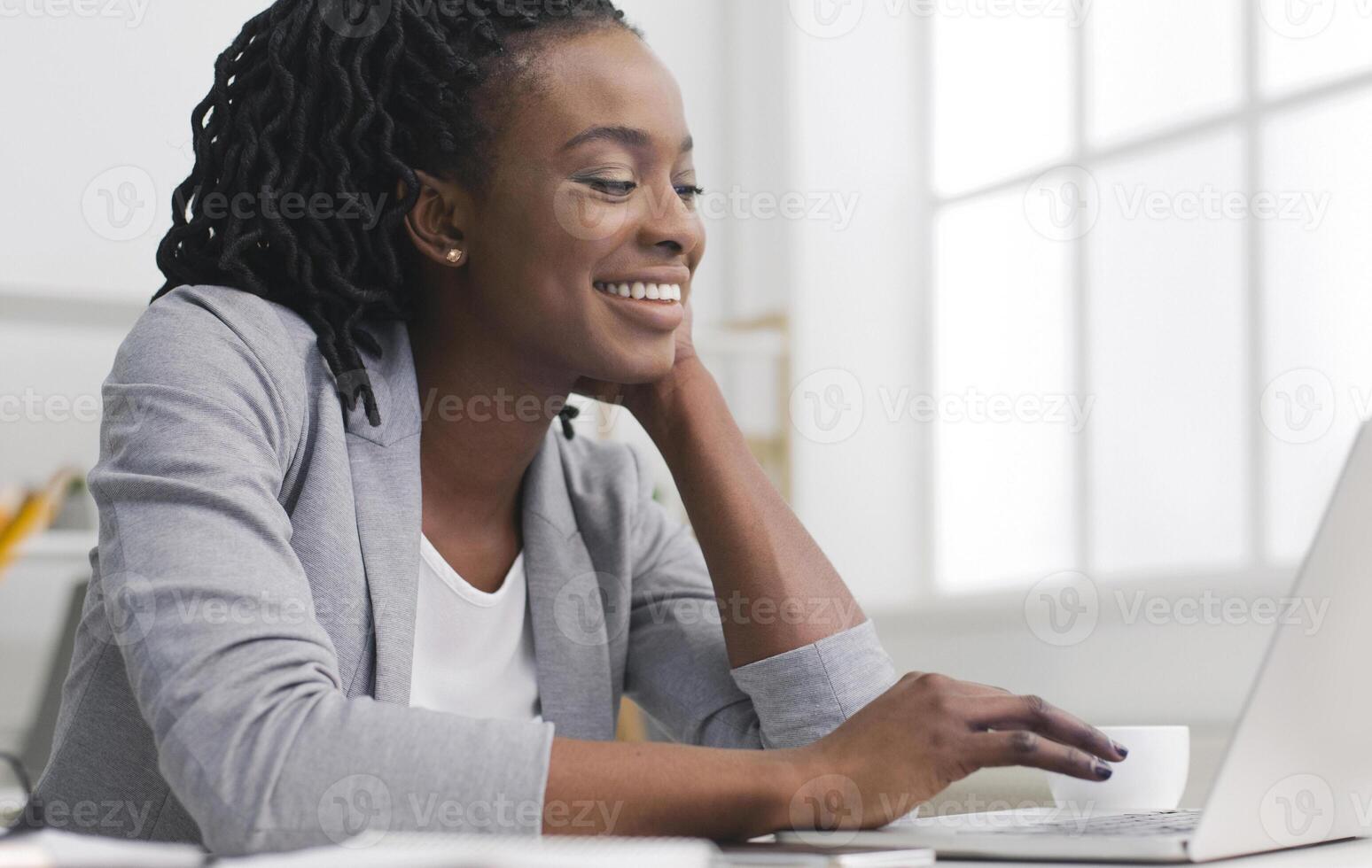 Smiling Afro Businesswoman Typing Something Working On Laptop In Office. Copy Space photo