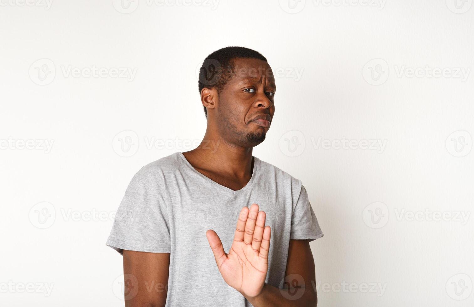 Black man expressing disapprovement, rejecting hand gesture, on white studio background. Negative emotions photo