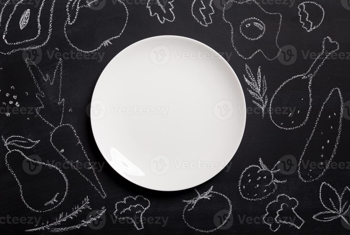 Hand drawn food on chalkboard and empty white plate, top view. Mockup for restaurant menu with copy space on platter photo