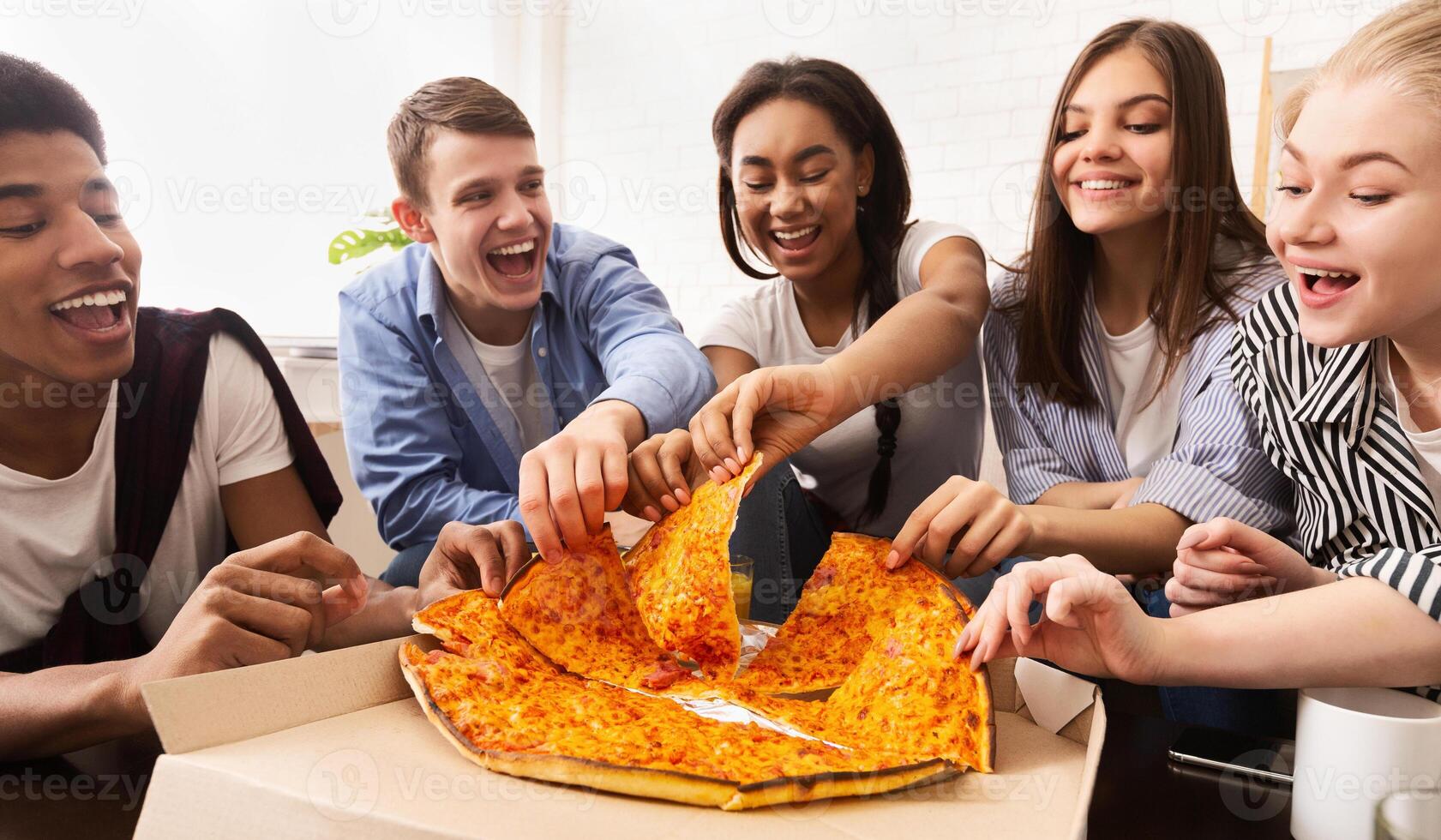 Pizza time. Teen friends sharing fast food together, relaxing at home on weekend photo