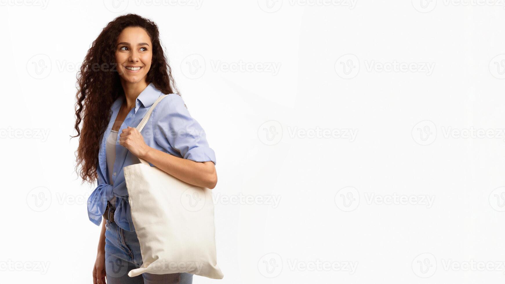 No Plastic. Happy Woman Carrying Flax Eco Bag Posing Looking Aside On White Studio Background. Eco-Friendly Shopping, No Plastic Life, Ecology Concept. Panorama With Copy Space photo