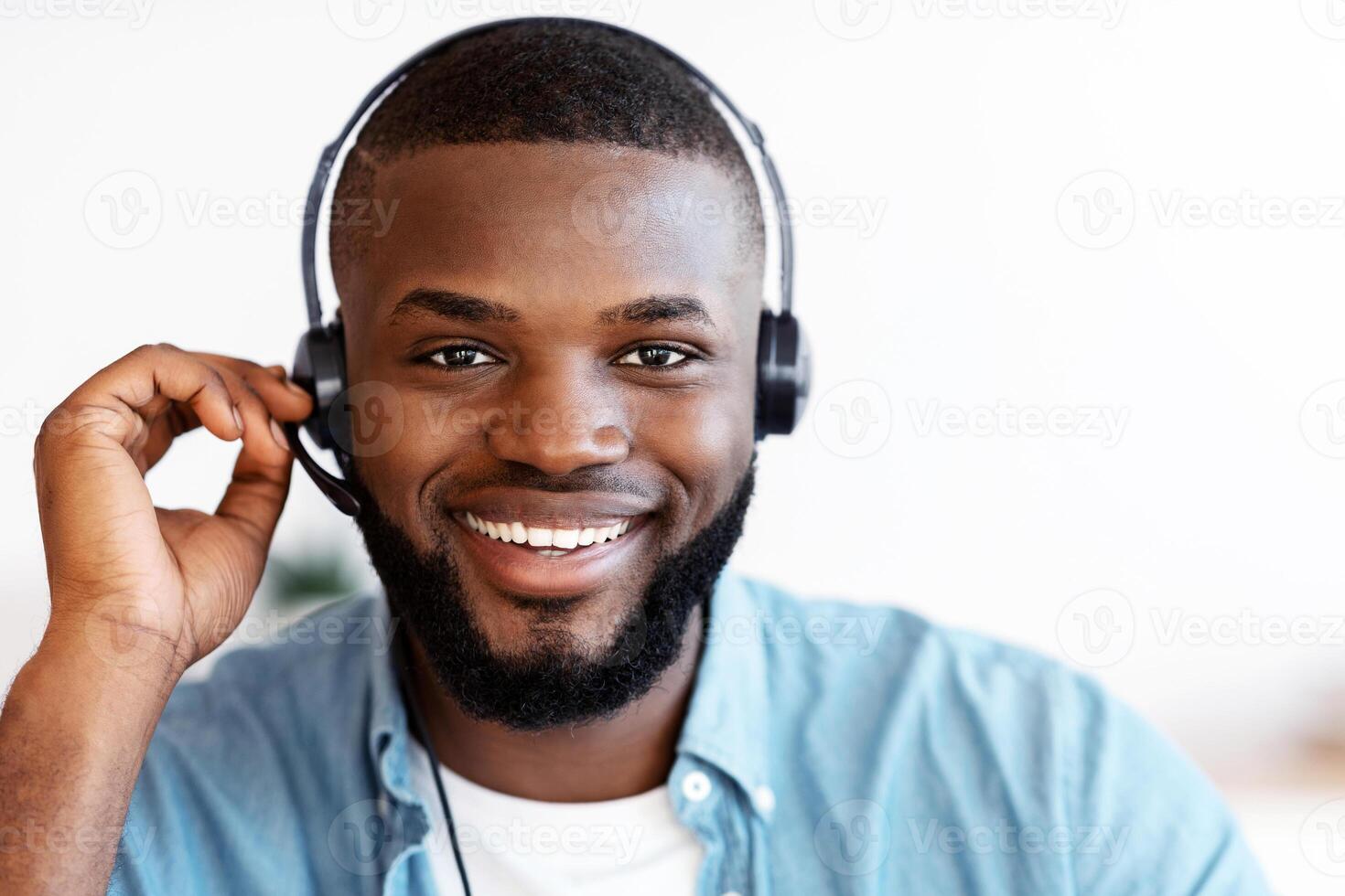 Call Center Operator. Closeup shot of friendly black man hotline manager in headset, portrait of handsome african american customer service representative looking at camera and smiling, free space photo