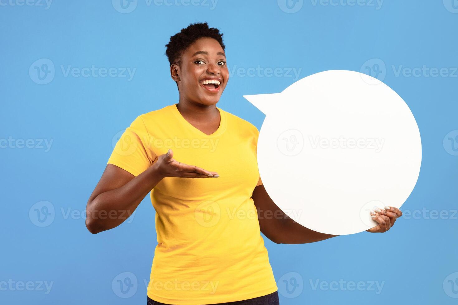Happy Black Lady Posing With White Speech Bubble Showing Her Opinion And Thoughts Standing Over Blue Studio Background, Smiling To Camera. Feedback, Comment Concept. Mockup photo