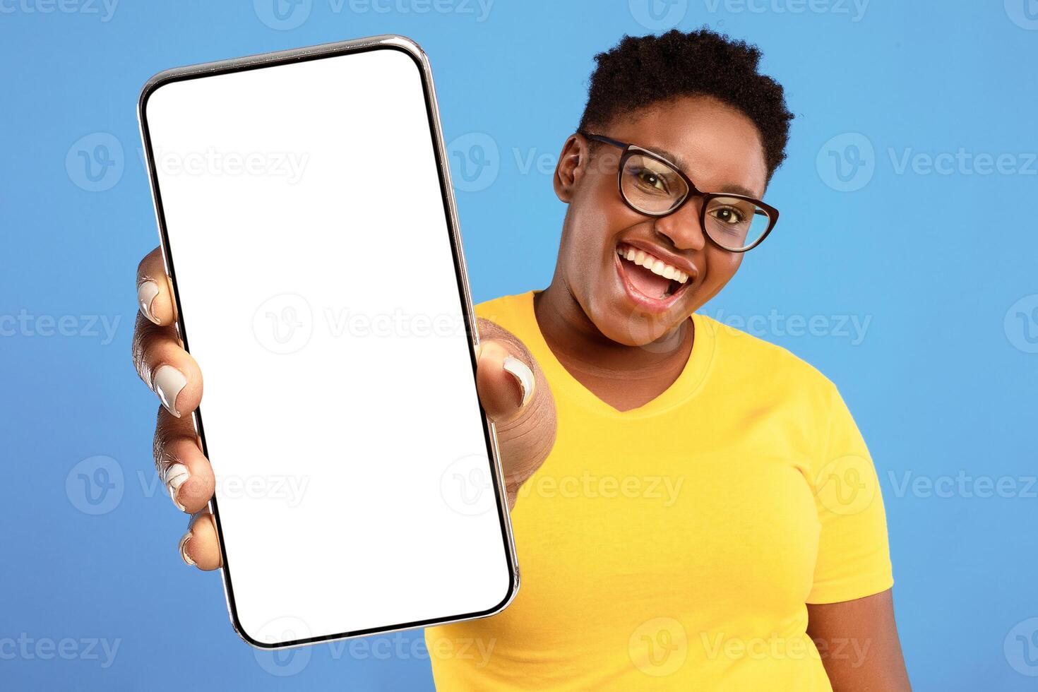Cheerful African Plus-Size Woman Gesturing Okay Sign Posing Standing Over Blue Studio Background, Smiling To Camera. I Am OK. Black Lady Approving Something Wearing Eyeglasses photo