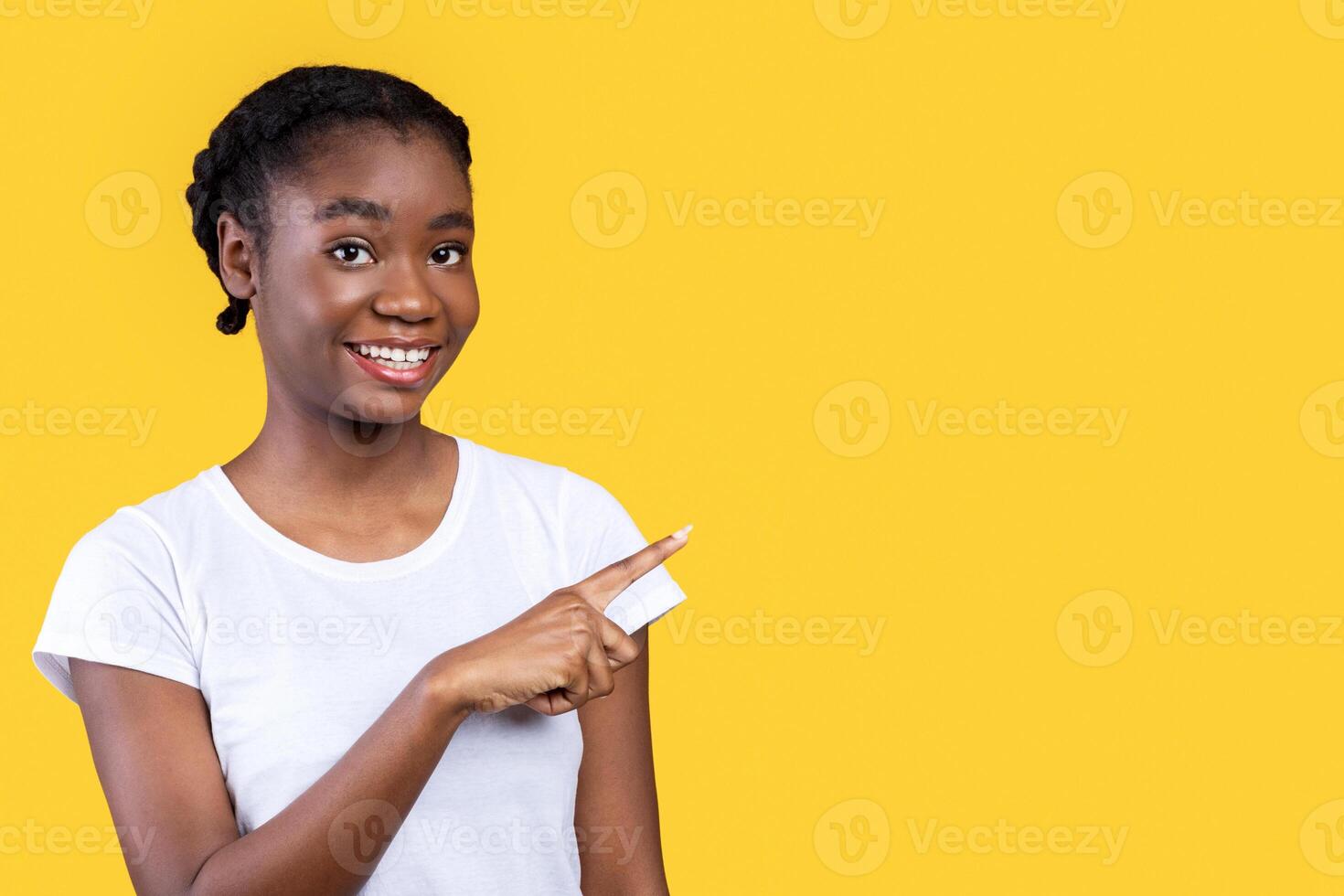Look There. Smiling African Woman Pointing Finger Aside At Free Space Advertising Your Text Standing On Yellow Studio Background. Check This Out Concept. Advertisement Banner. Panorama photo