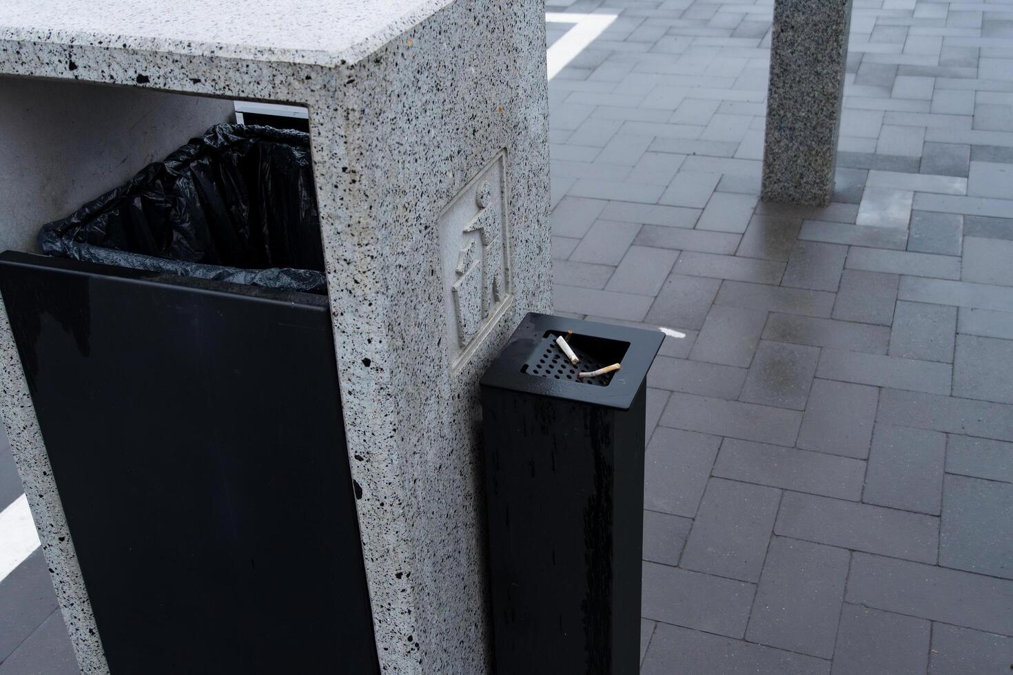 A sleek and contemporary garbage container stands in a bustling public area, designed to encourage responsible waste management photo