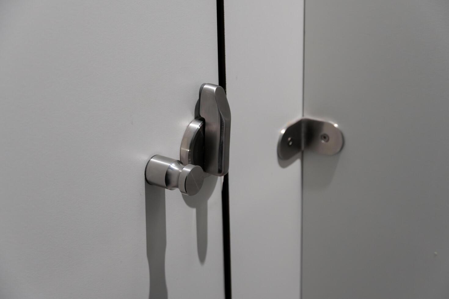 Close-up of a modern cabinet featuring a sleek metal lock and handle. The design showcases a minimalist approach, ideal for contemporary interiors, emphasizing both style and security photo