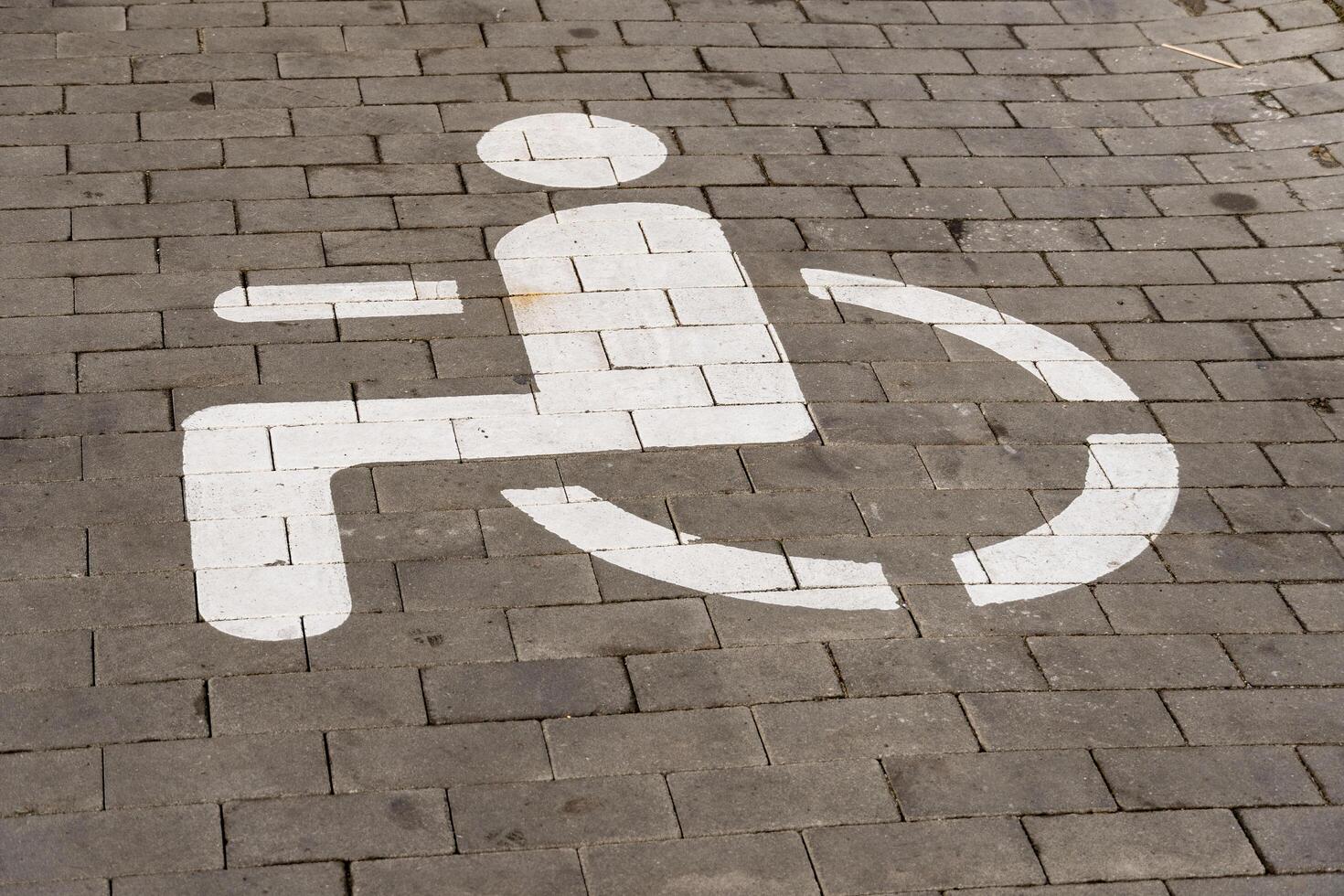 A white symbol indicating wheelchair accessibility is painted on a paved surface, highlighting the importance of inclusive transport options for people with disabilities in urban areas photo