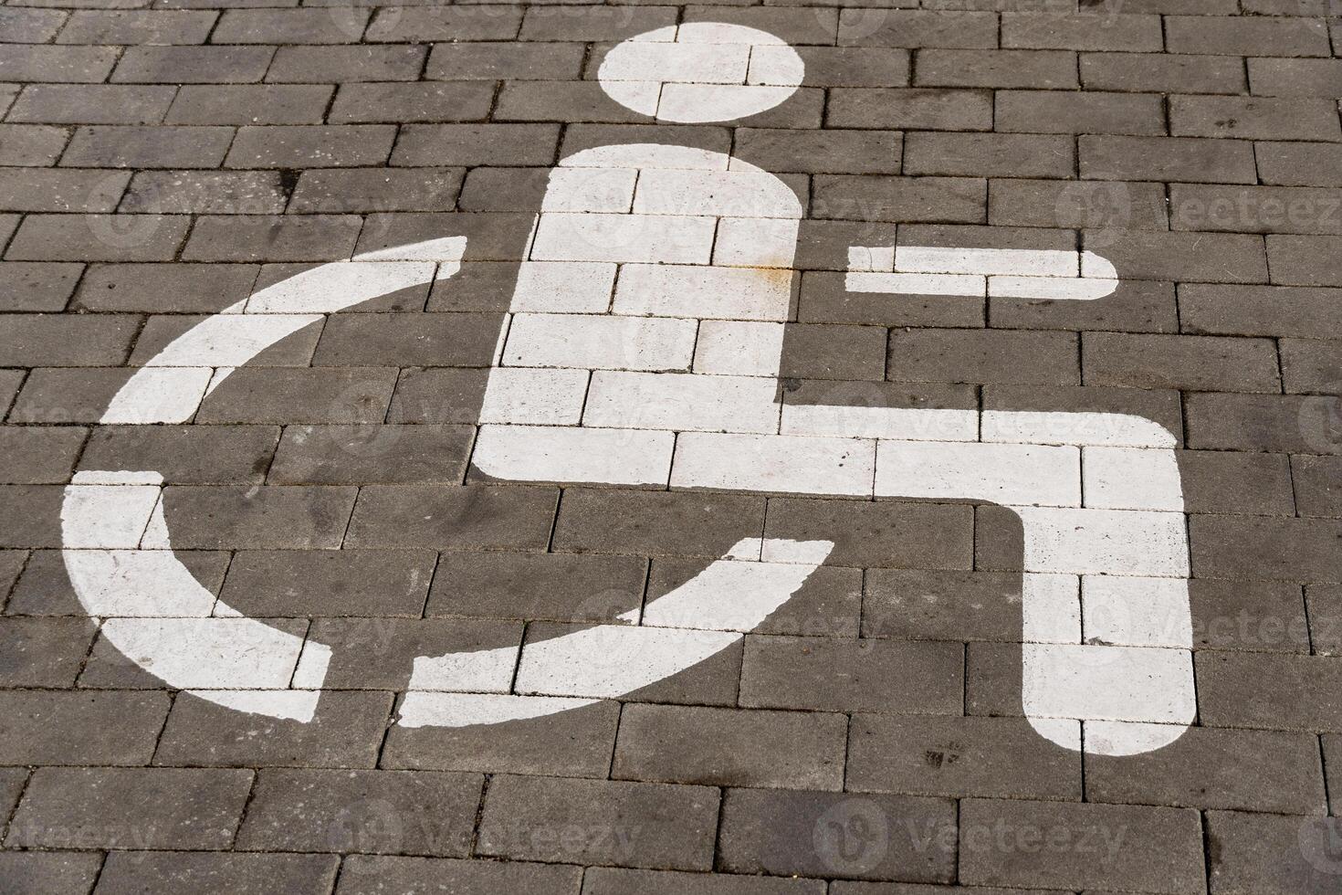 A prominent symbol for accessibility, painted on pavement, indicates designated parking for individuals with disabilities, ensuring ease of access in outdoor environments photo