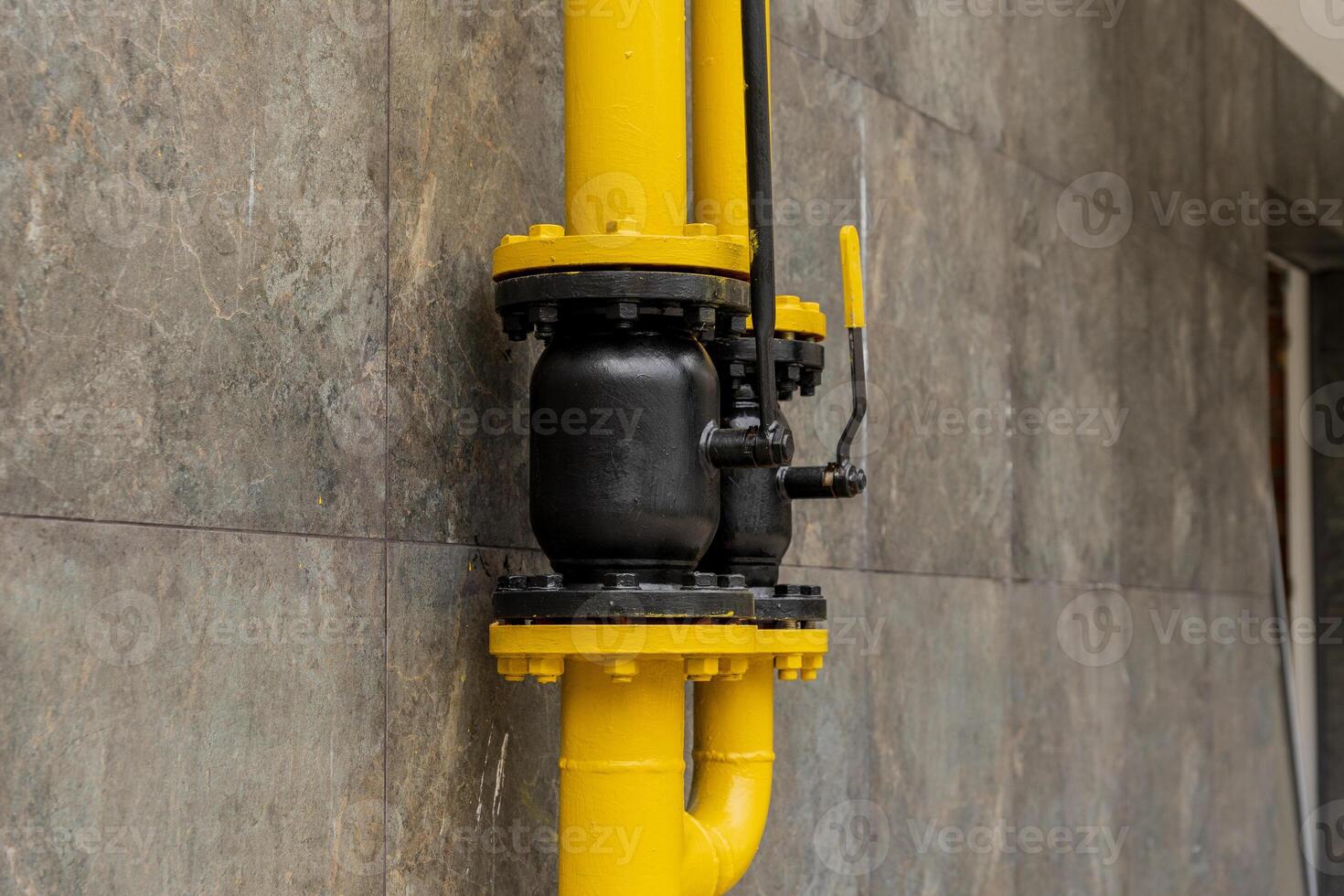 A brightly colored yellow and black gas pipeline connection illustrates the sophisticated technology used for transporting energy in industrial settings photo