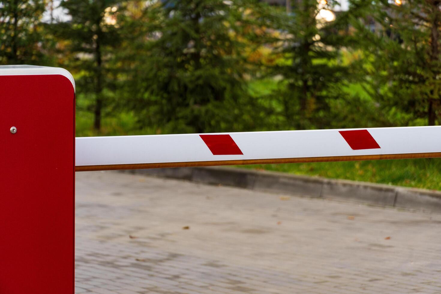 The automatic barrier gate is closed, managing vehicle access to the parking lot. The setup ensures safety and control of entry points while maintaining a clear boundary photo