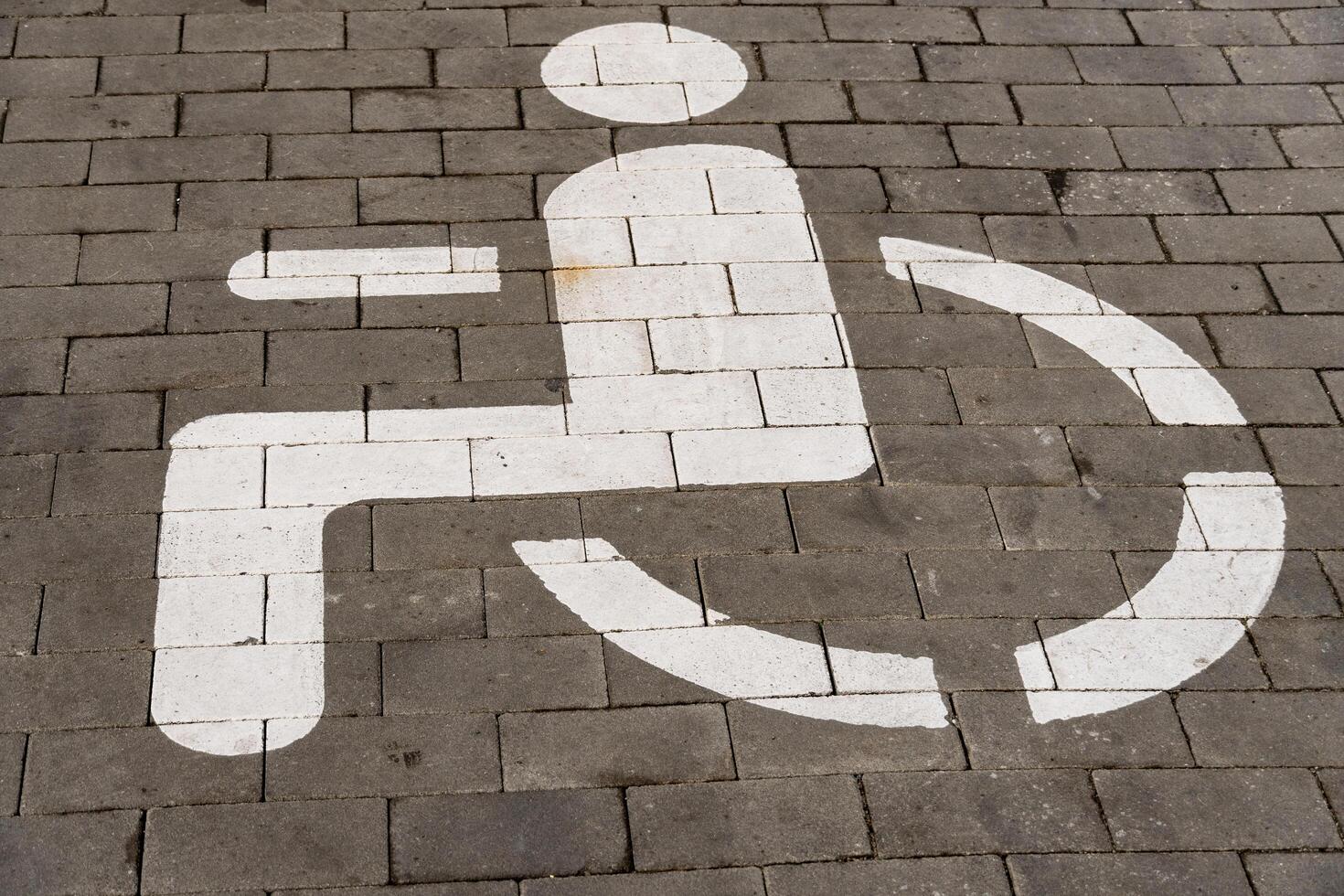 A clear symbol indicating wheelchair accessibility is marked on the ground. This sign is crucial for identifying designated parking areas for individuals with disabilities photo