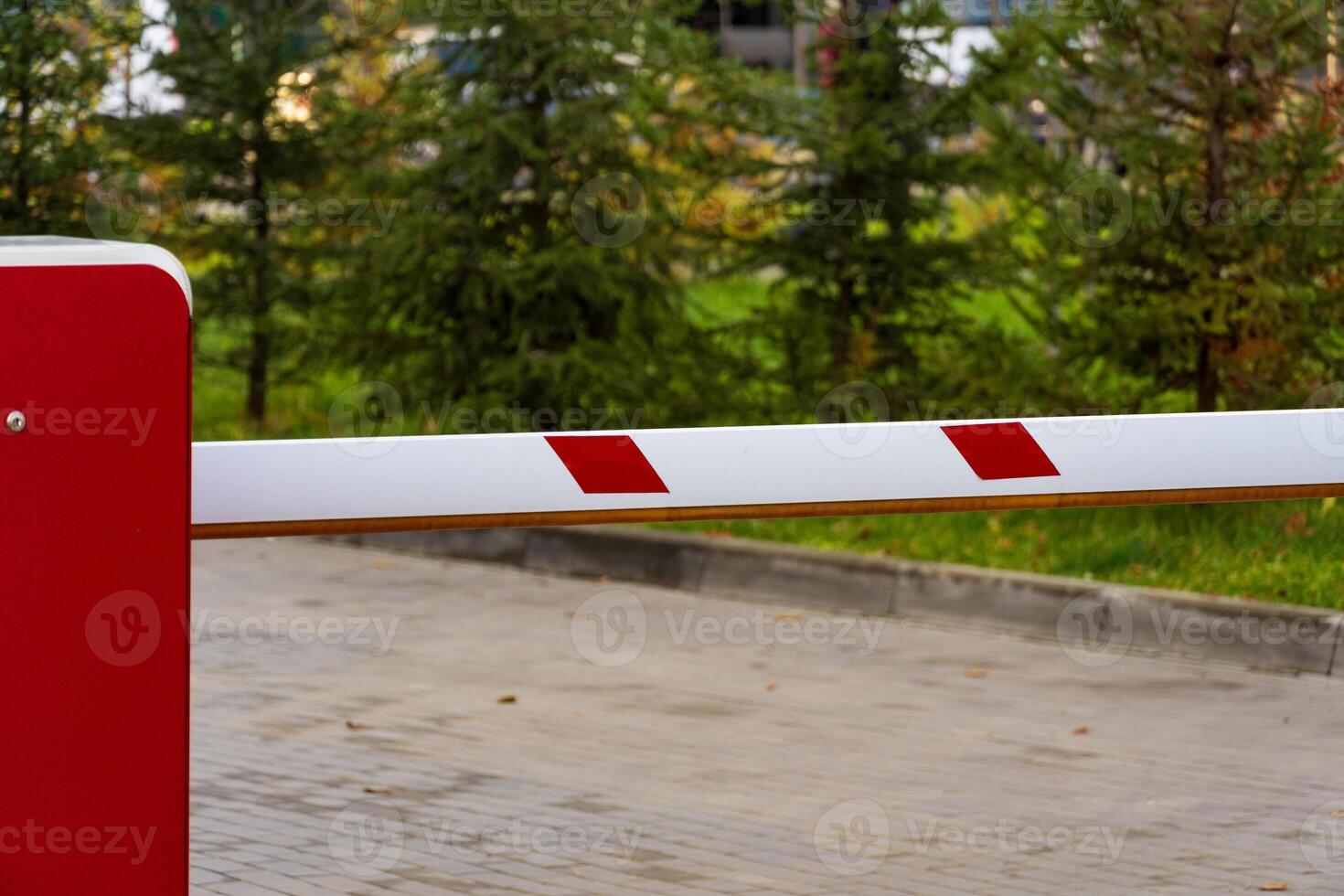 An automatic security barrier is positioned at the entrance of a parking lot, ensuring controlled access and safety for vehicles. The closed gate features red and white markings photo