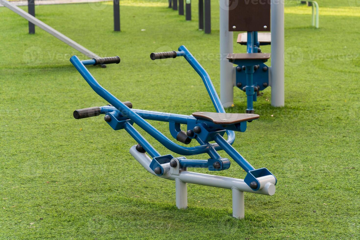 Outdoor fitness area features modern exercise machines designed for public use. Residents engage in physical activity to promote a healthy lifestyle surrounded by green spaces photo