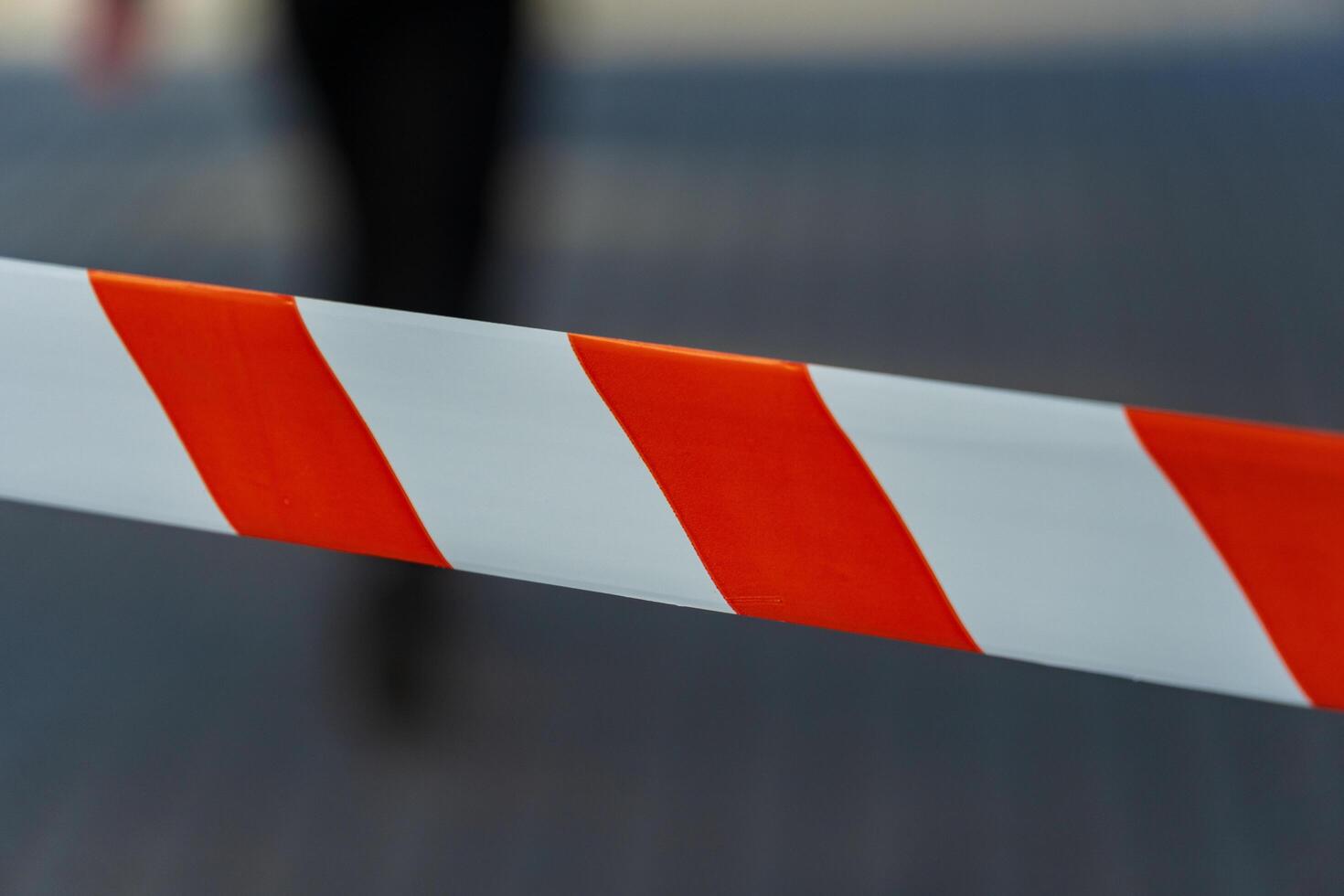 Brightly colored caution tape is prominently displayed against a blurred urban background, marking an area of restriction for public safety during ongoing construction work photo