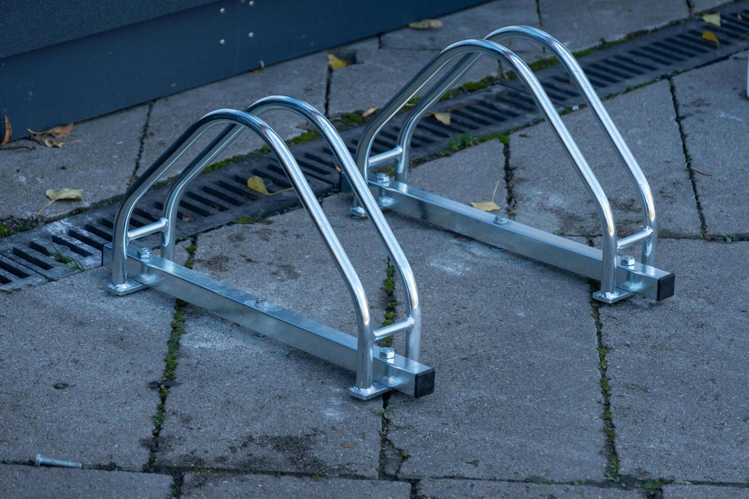 Well-designed bicycle racks stand ready for riders in a bustling neighborhood. The metallic structure gleams under sunlight, inviting cyclists to securely park and thrive photo