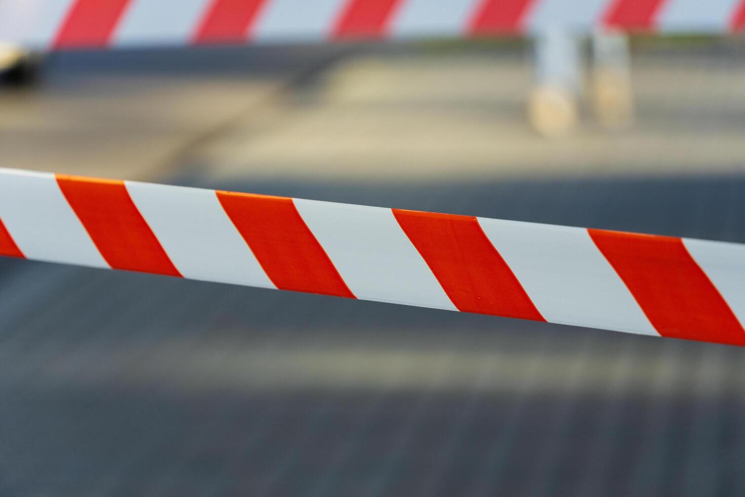 Vibrant cautionary tape winds across the pavement, alerting passersby to a nearby hazard. Its bold colors stand out against the muted urban backdrop, ensuring visibility photo