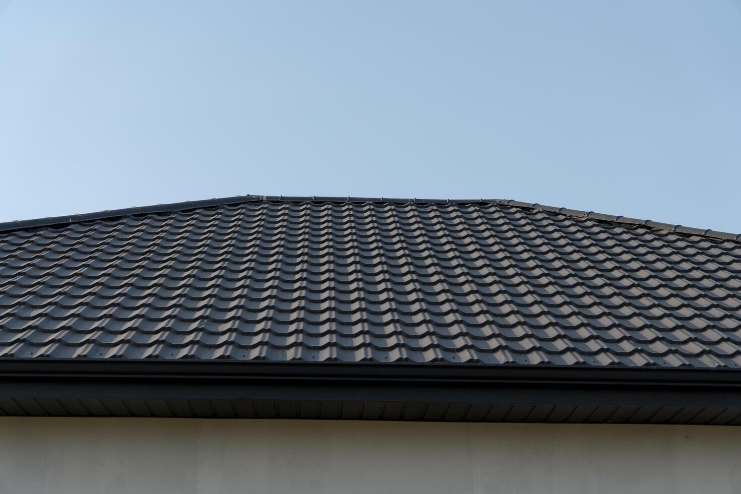 A striking roof adorned with patterned tiles reflects modern design, contrasting beautifully with the bright blue sky above. The geometry creates a sense of harmony and structure photo
