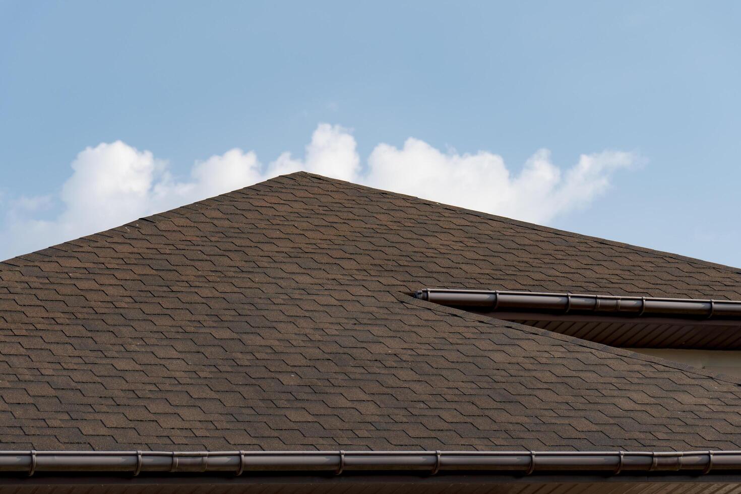 The distinct lines of a well-designed roof contrast against a vibrant blue sky, creating a tranquil atmosphere. Soft clouds gently drift in the background, enhancing the peaceful vibe photo