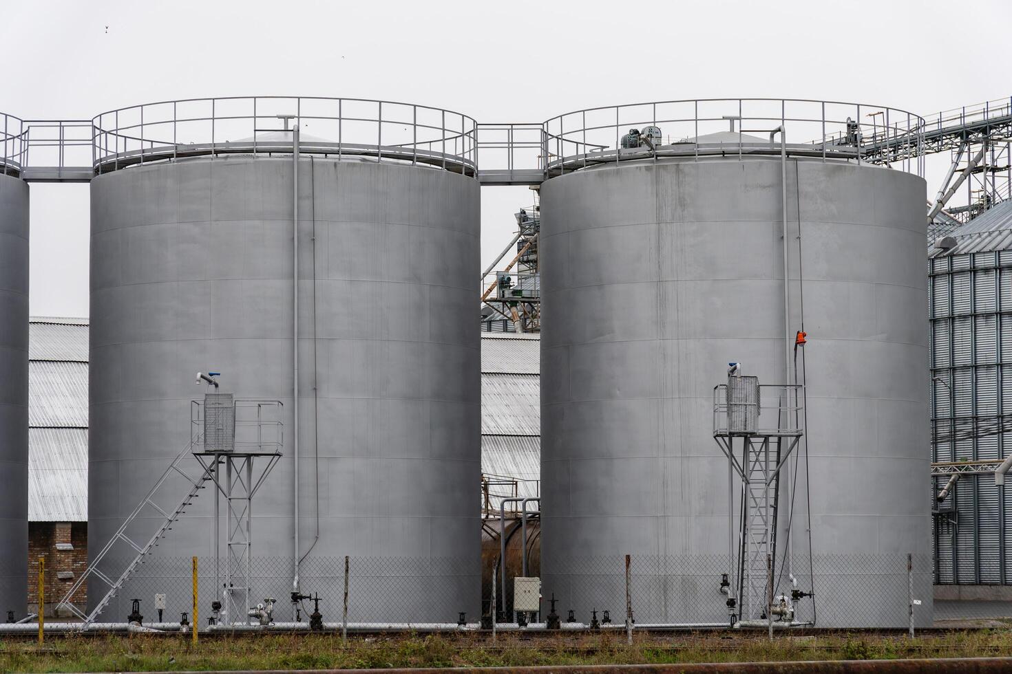 Large fuel storage tanks stand side by side in an industrial setting, utilized for storing various fuels. The structures highlight the importance of energy resources photo