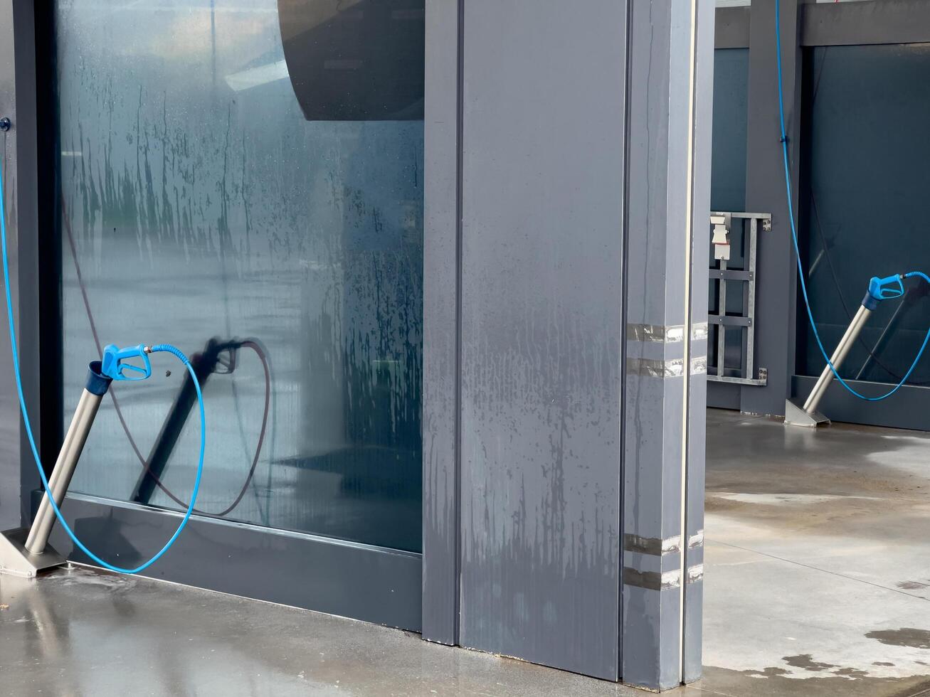 The car wash area showcases state-of-the-art cleaning equipment with hoses ready for use, providing an efficient car cleaning experience at the facility photo
