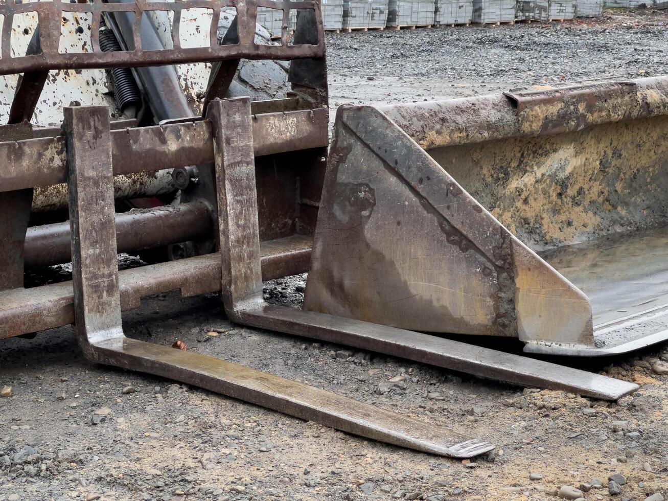 A robust bulldozer equipped with a grader attachment is stationed at a busy construction site, poised for upcoming earth-moving projects photo