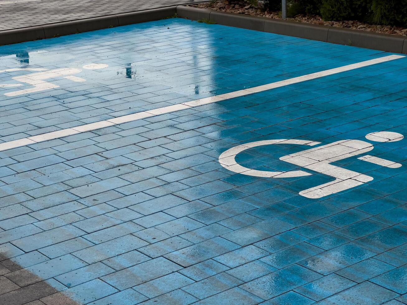 A clear blue pavement designated for accessible parking features the iconic disability symbol. It showcases dedication to inclusivity in urban planning for those with mobility challenges photo