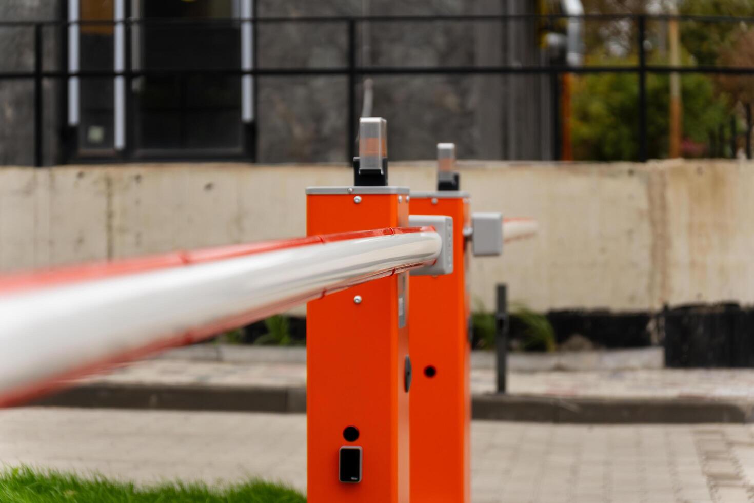 A closed barrier gate secures an entry point, restricting access to vehicles in a well-defined boundary of a contemporary urban area, ensuring safety and control photo
