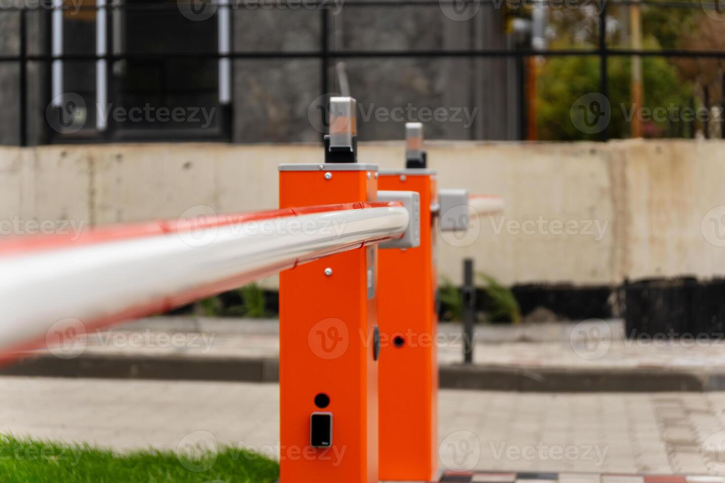 This bright orange barrier stands prominently, regulating entry to a secure location in a modern urban area. The strong design emphasizes security and control photo