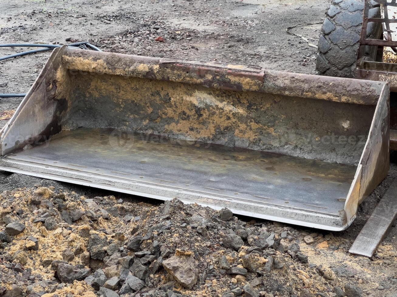 A bobcat is positioned next to a bulldozer and tractor at a construction site. The ground is disturbed, indicating active land preparation for upcoming work photo