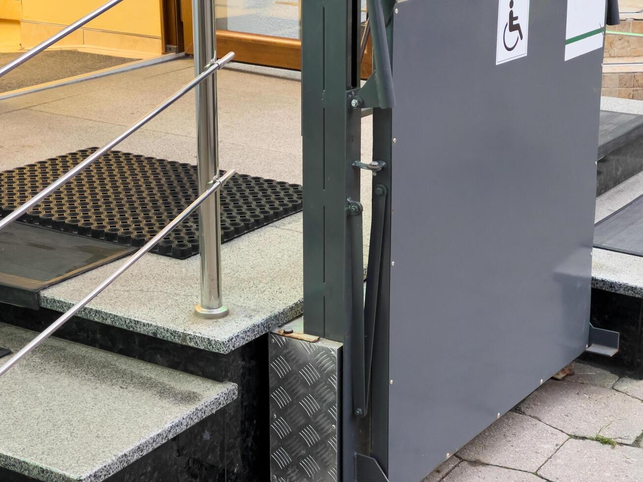 A sleek, metallic ramp stands ready by a set of stairs, designed for those with mobility impairments, promoting inclusivity and accessibility for all photo