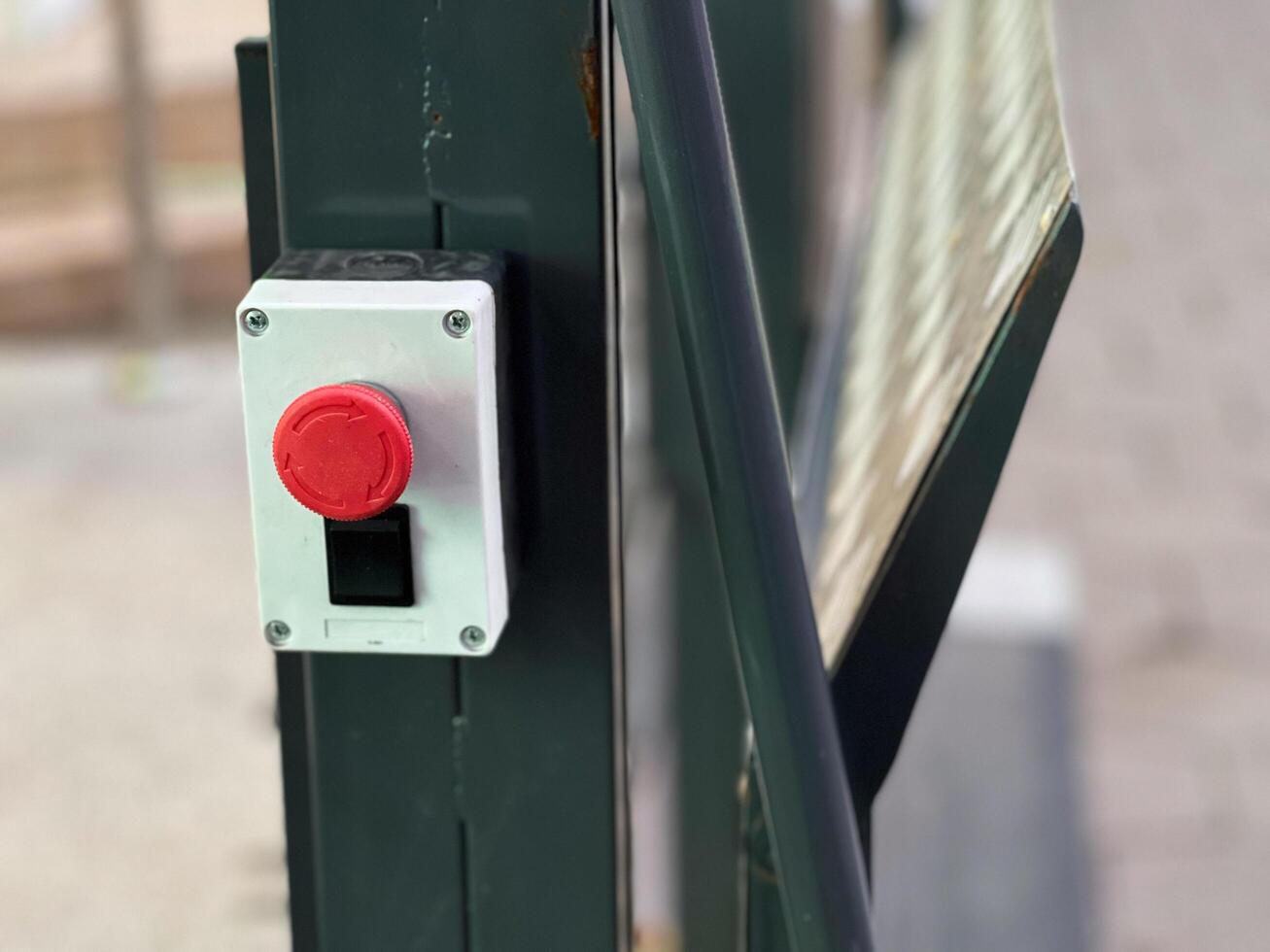 The striking red button, positioned at eye level, signals a commitment to safety, urging prompt action in emergencies at this bustling outdoor location photo