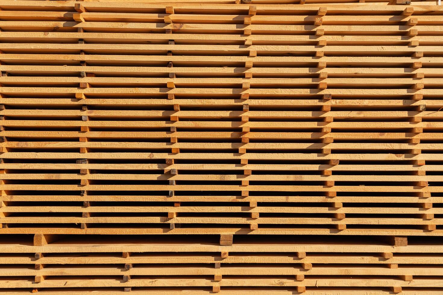 Lumber workers have arranged multiple wooden planks in an orderly fashion, showcasing their smooth surfaces under the afternoon sun, highlighting the natural colors photo