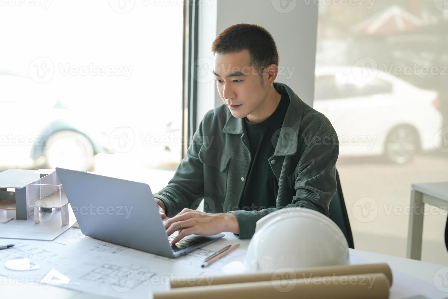 Architecture man sitting at a desk with a laptop. photo