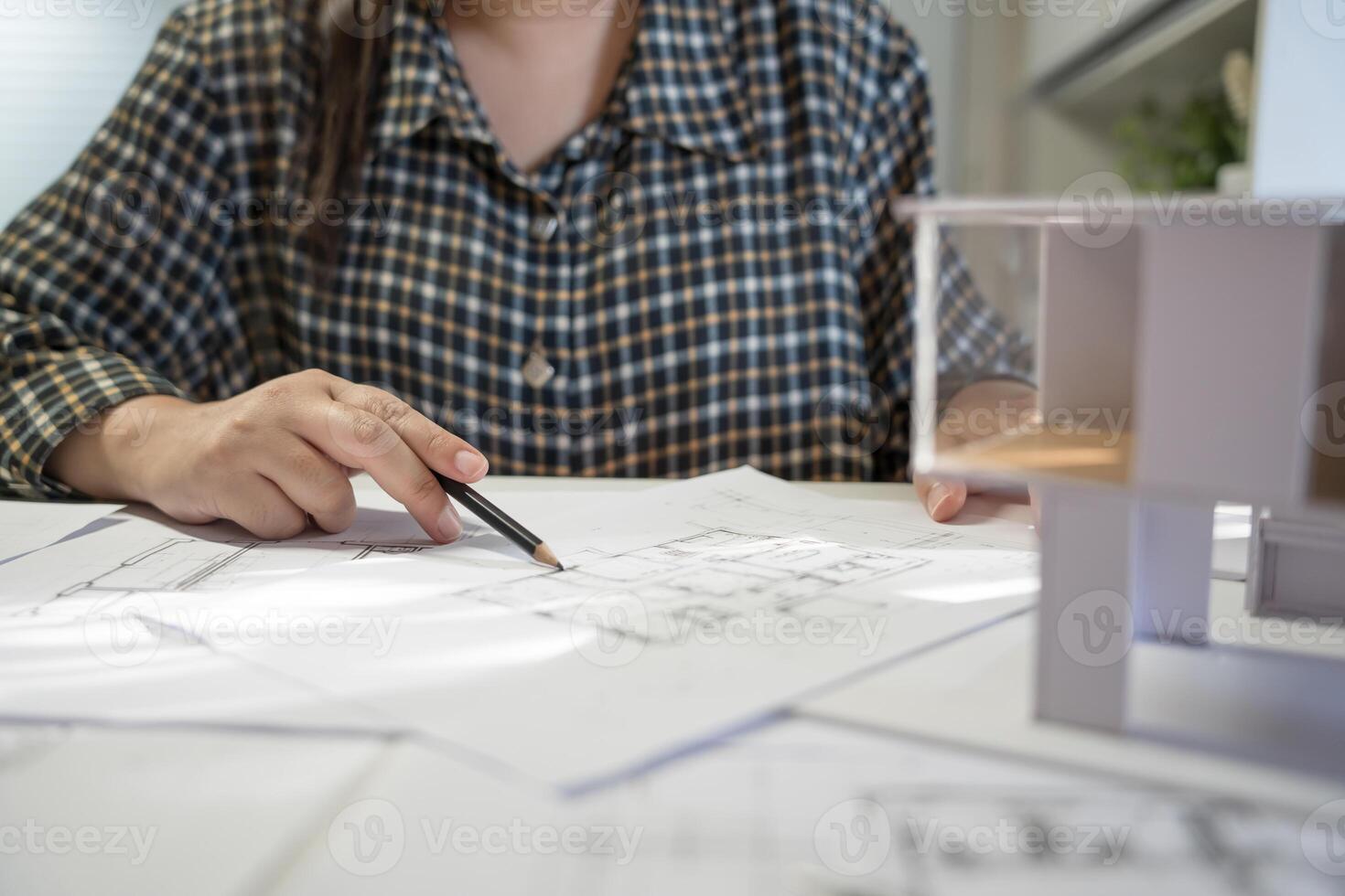 woman is working on a model of a house. photo