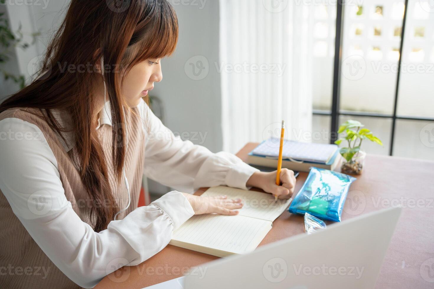 a woman sitting at a desk with a notebook and pen online learning class photo